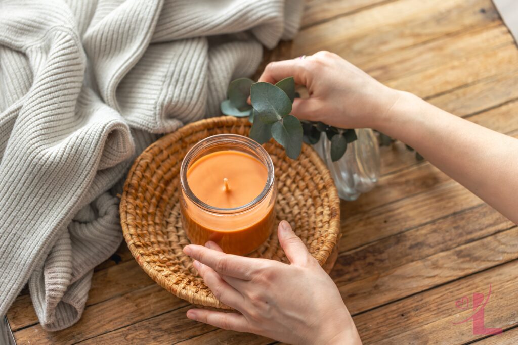 Self-Care Practices for UK Women: What Actually Works (and What Doesn't) 5 Hands holding a lit candle surrounded by soft textures as part of a self-care ritual