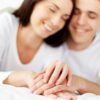 Close-up of a couple's hands, warm soft lighting, representing an open conversation about intimacy