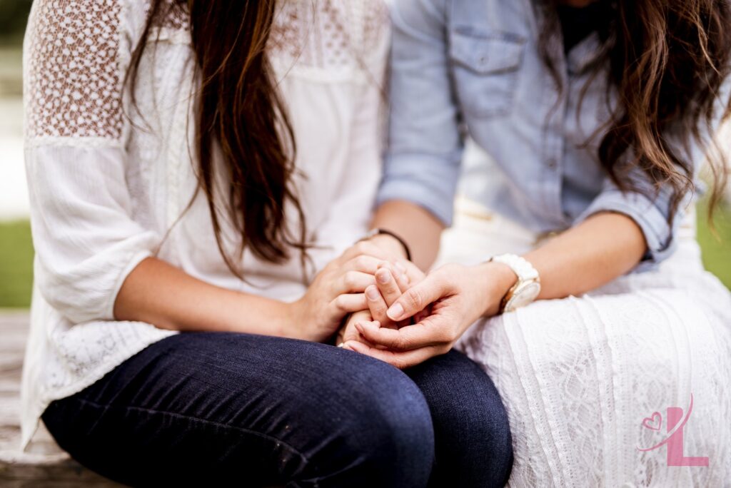 What Happens to Your Body When You're Turned On (and Why Rushing Hurts) 5 Two women holding hands closely, with a softly blurred background