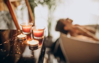 Woman relaxing in a warm bath with bubbles, embodying self-care and intimate wellness
