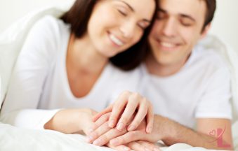 Close-up of a couple's hands, warm soft lighting, representing an open conversation about intimacy