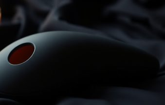 Premium air-pulse and sonic clitoral stimulators on dark silk — luxury adult wellness
